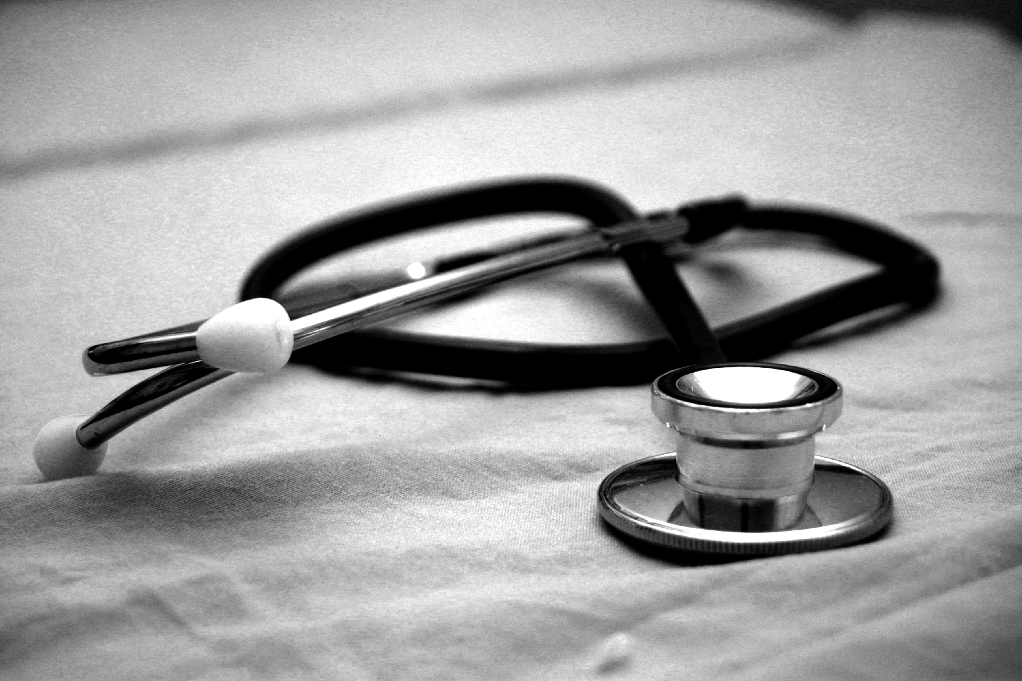 Black and white photo of a doctors stethoscope on plain fabric